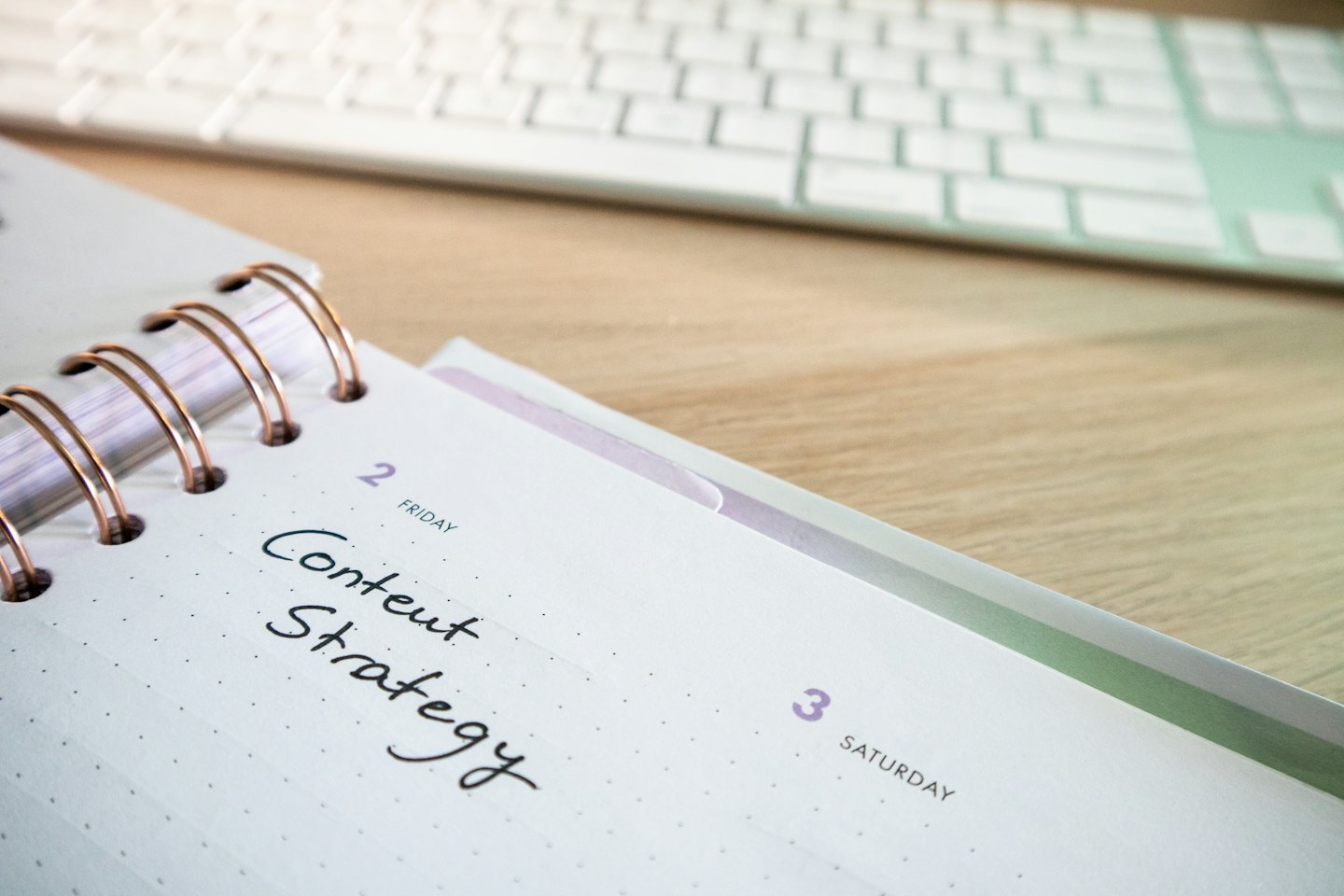 Agenda ad anelli aperta con la scritta 'Content Strategy' su una pagina.